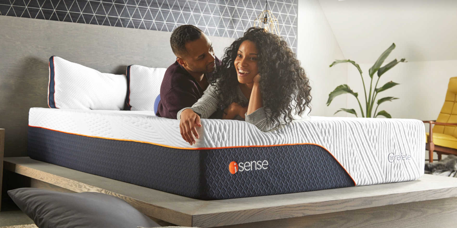 Photo of couple testing out an iSense mattress, very happy.