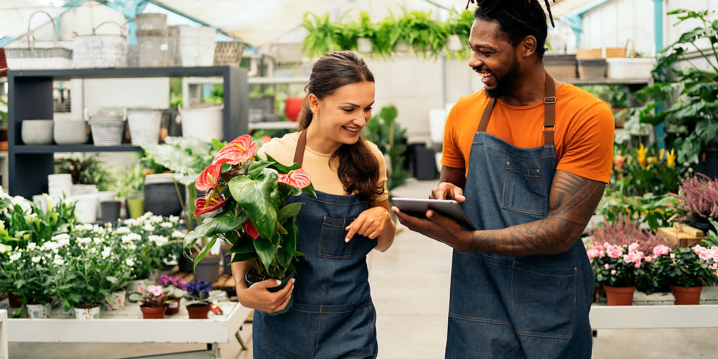 Male and female workers in a garden center discussing biz plans for success in 2021