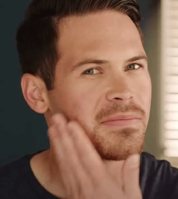 Man touching his goatee beard, showing a classic goatee style  