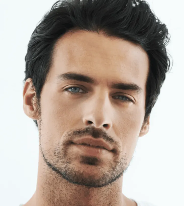 Man with an oval-shaped face and light stubble, facing forward