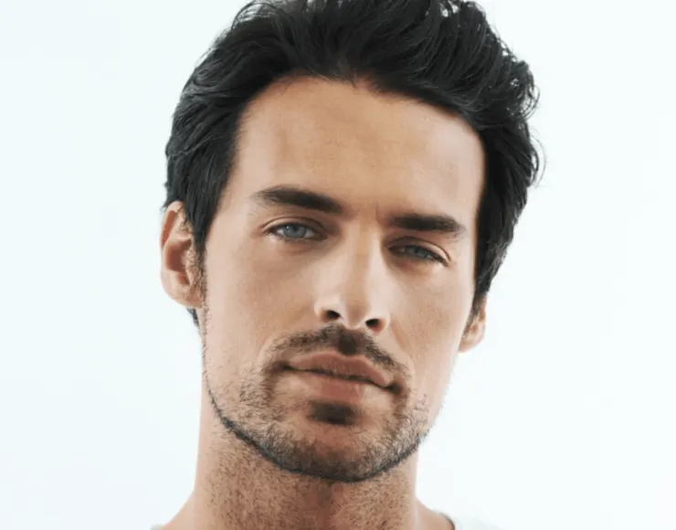 Man with an oval-shaped face and light stubble, facing forward