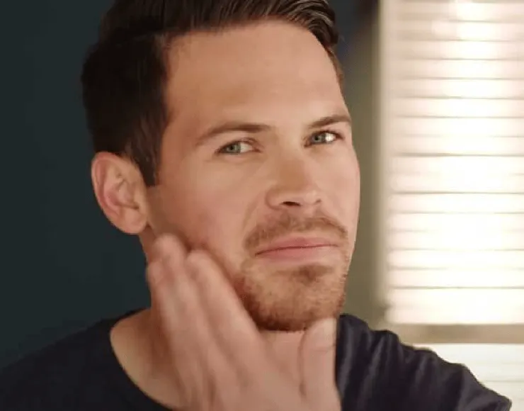 Man touching his goatee beard, showing a classic goatee style  