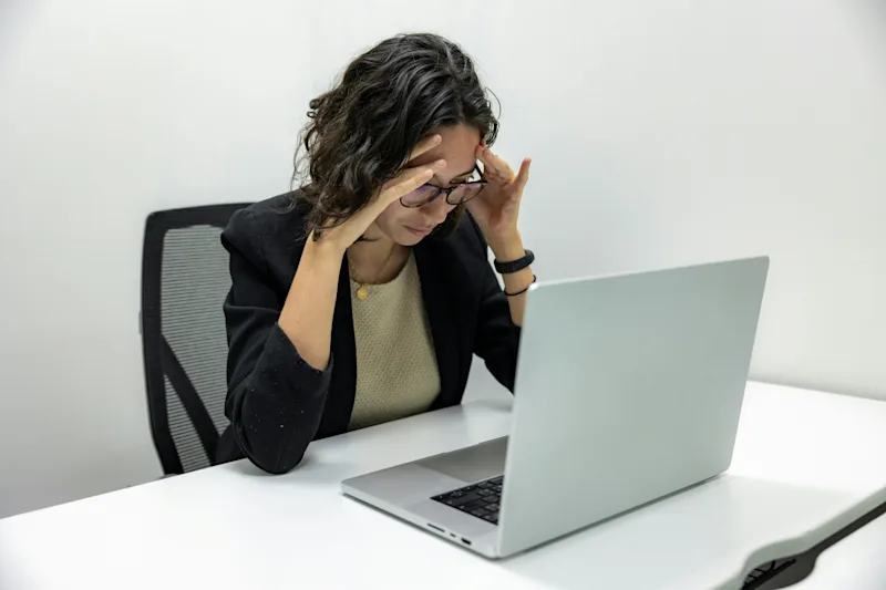 person stressed looking at laptop messages