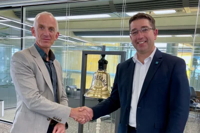 Nick Brown (CEO of Lloyd's Register) and Martin Taylor (CEO of OneOcean Group) shaking hands on the acquisition of OneOcean by Lloyd's Register.