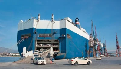 Image of a roll-on roll-off vessel in port with cars driving off the ship