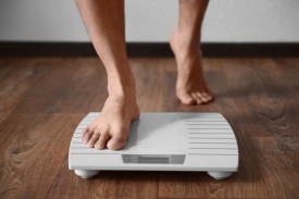 Man stepping onto scales - weight loss can help to treat type 2 diabetes