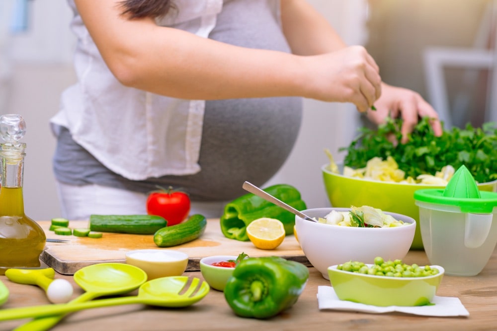 Pregnant woman with gestational diabetes making a salad for lunch