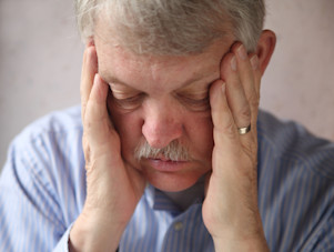 Man with diabetes has hands over his face, as to indicate burnout