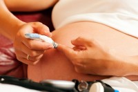 Pregnant woman with gestational diabetes testing blood glucose levels
