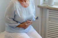 woman holding stomach - some people who use metformin experience diarrhoea