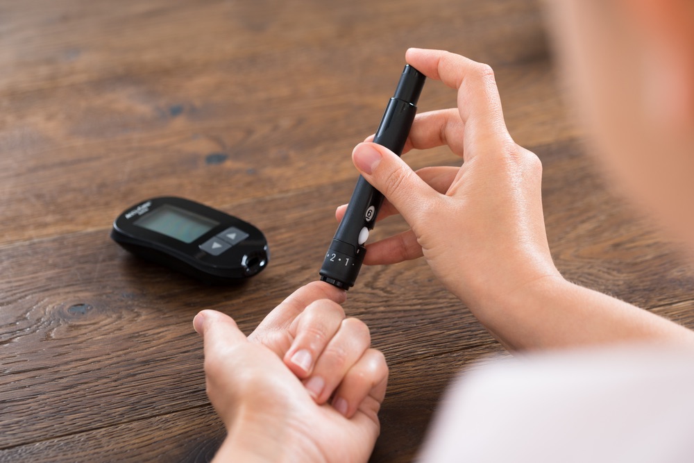 Woman with prediabetes testing her blood glucose levels with a glucometer