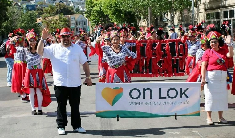 On Lok seniors and team walking in the parade at the 2024 Carnaval parade in San Francisco.