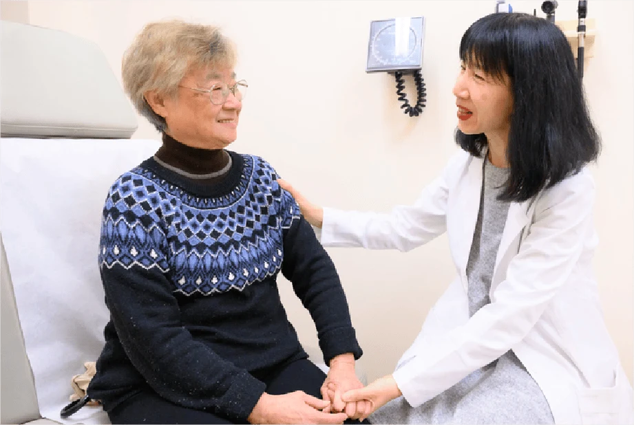 OnLok's primary physician, Hong Wu, MD, looks over a patient