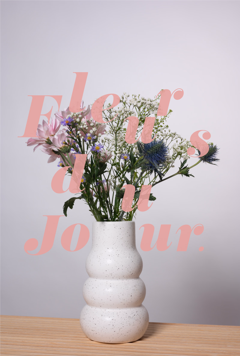 Liiloja kukkia ja harsokukkaa pulleassa valkoisessa maljakossa, päällä teksti 'Fleurs du Jour'.