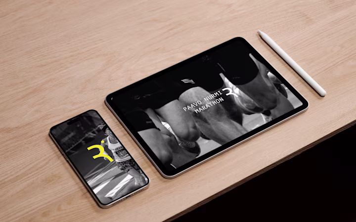 Tablet And Smartphone On Wooden Surface Showing Paavo Nurmi Marathon App Interface With Black And White Runner Images.