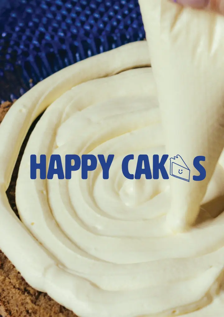 The Picture Shows A Close Up Of Someone Applying A Smooth, Creamy Frosting In Circular Motions On Top Of A Cake Using A Piping Bag. The Frosting Appears Rich And Thick, Creating A Visually Appealing Texture That Emphasizes The Craftsmanship Involved In The Cake Making Process.  In The Center Of The Image, The Brand Name "HAPPY CAKES" Is Prominently Displayed In Bold, Blue Uppercase Letters. The Font Is Playful Yet Clear, Reflecting A Joyful And Friendly Brand Identity. The Letter "E" In "CAKES" Is Stylized As A Slice Of Cake With A Smiley Face, Reinforcing The Cheerful And Approachable Nature Of The Brand. This Small Icon Adds A Whimsical Touch, Making The Brand Feel Warm And Inviting.  The Overall Color Scheme Is Primarily Focused On The Natural Tones Of The Frosting And Cake, With The Blue Text Standing Out Vividly Against The Background, Making The Brand Name Easy To Read And Memorable. The Image Captures The Essence Of The Brand, Suggesting That "Happy Cakes" Is All About Creating Delicious, Joy Filled Experiences Through Their Baked Goods.