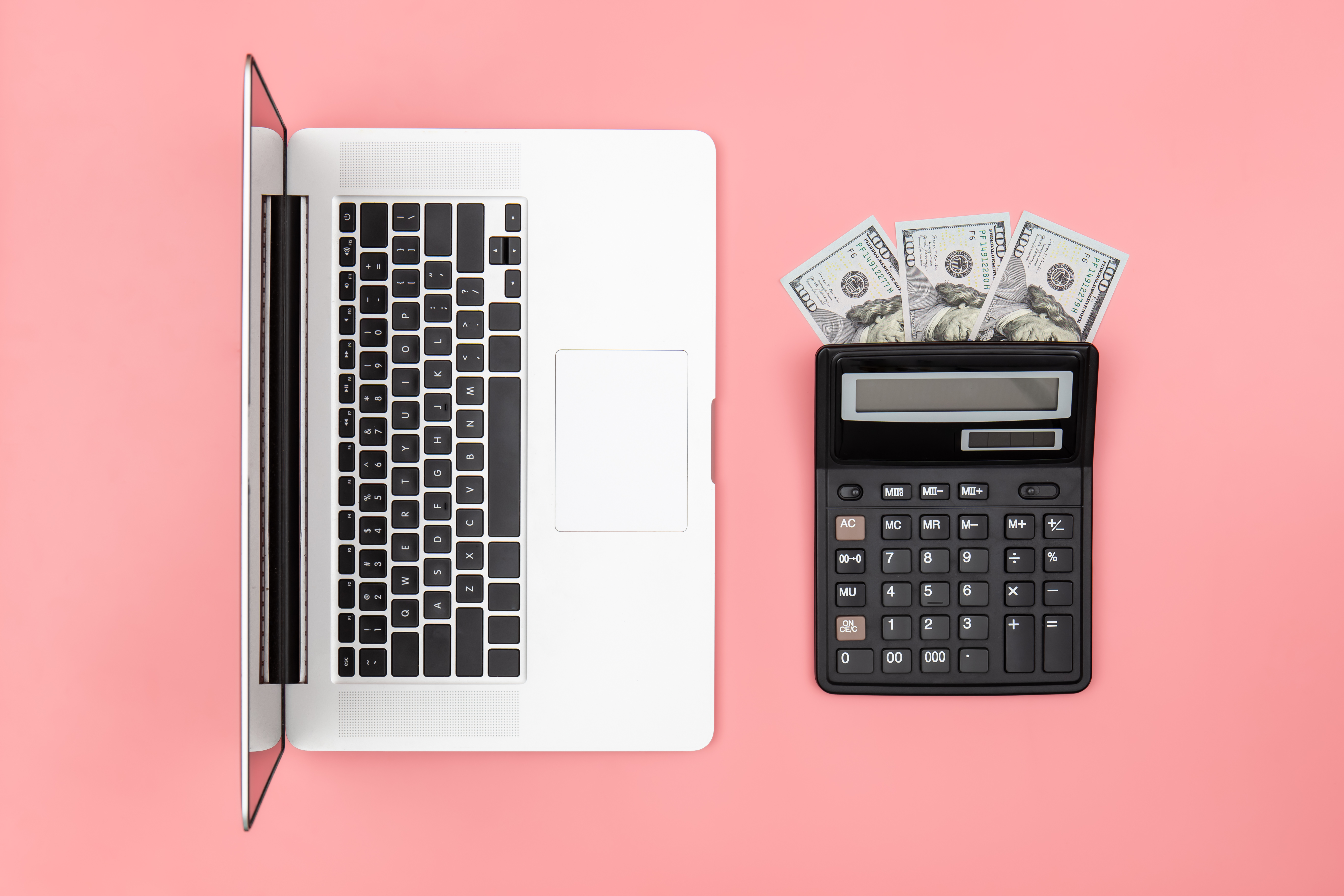 calculator-laptop-dollar-bills-colored-background-flat-lay