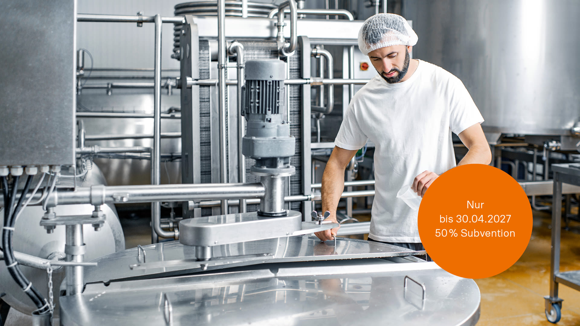Arbeiters in Uniform in der Nähe eines Edelstahltanks in einem Unternehmen der Lebensmittelindustrie