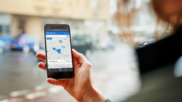 Frau sucht mit der Parcandi-App einen Parkplatz