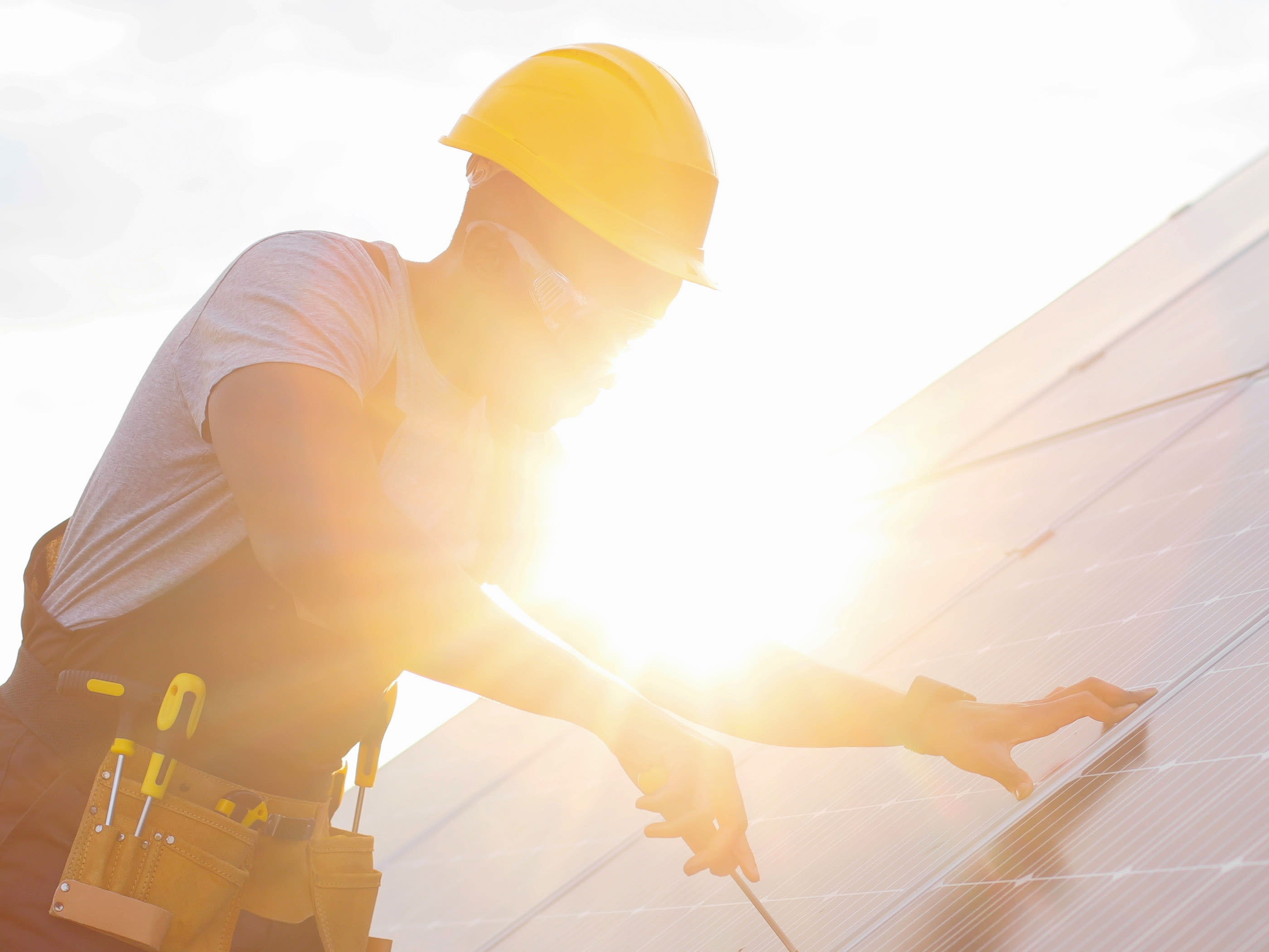 Una persona monta un impianto fotovoltaico sul tetto.