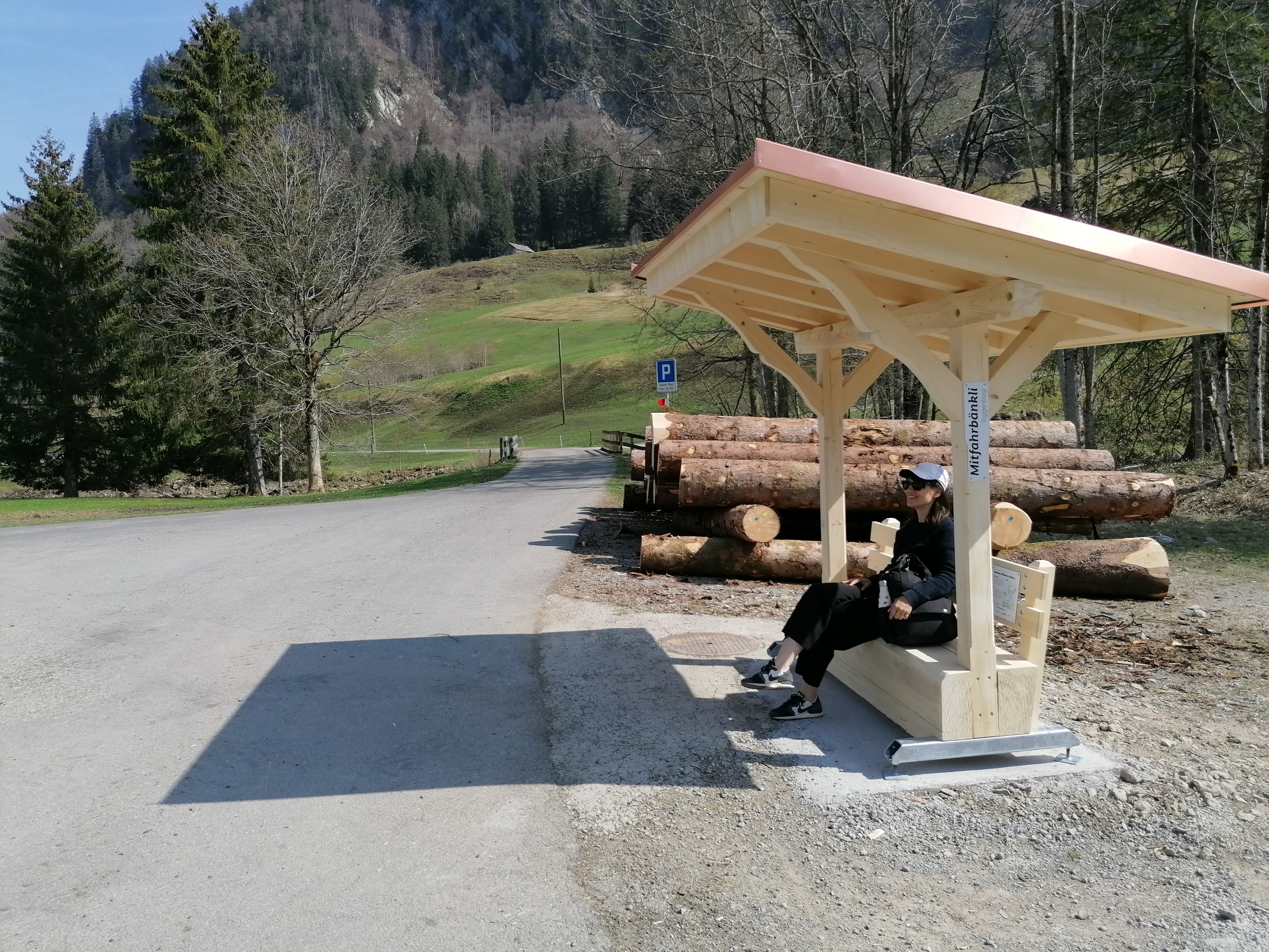 Une femme est assise sur le banc de covoiturage.