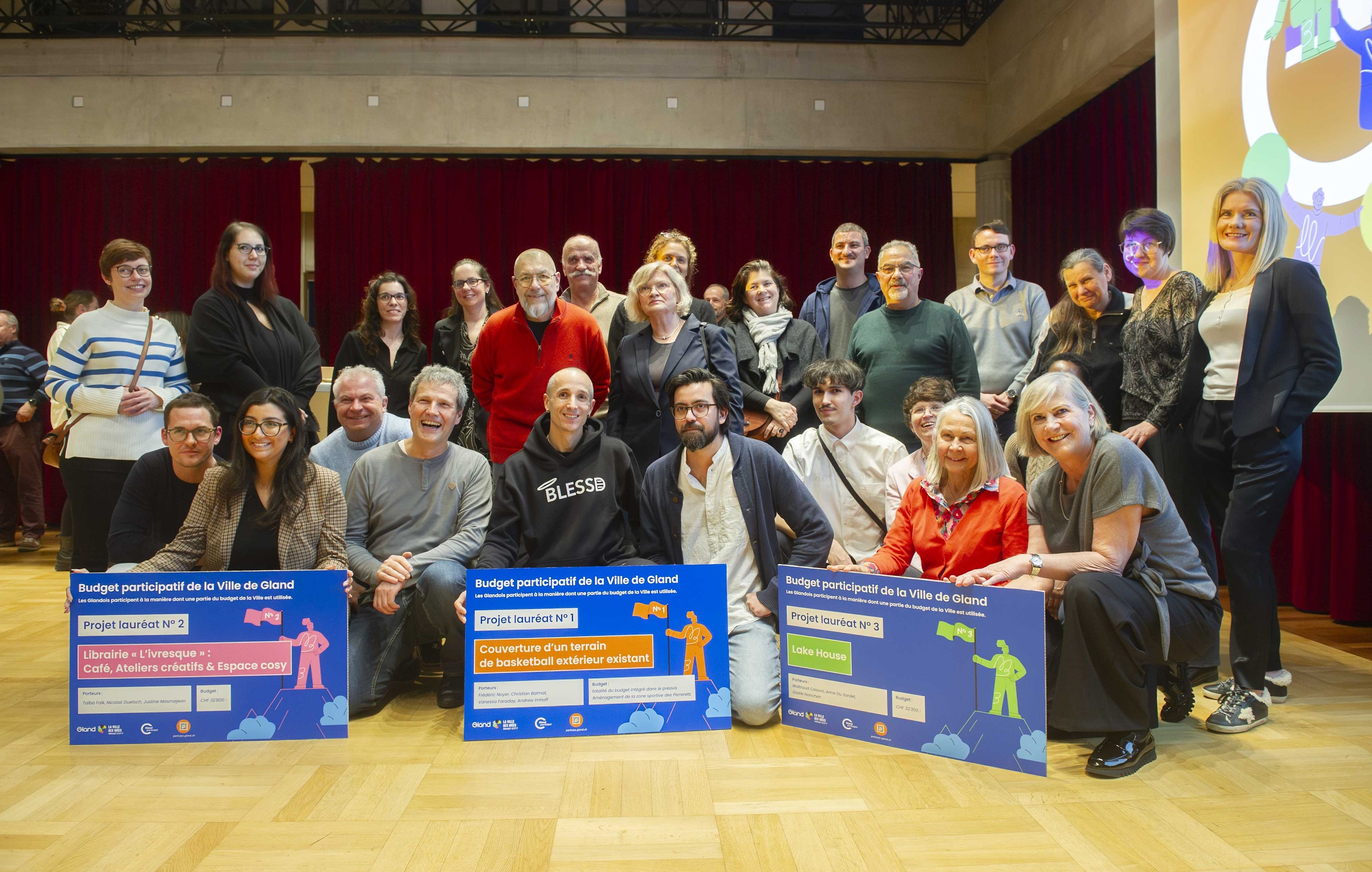 Photo de groupe des participantes et participants avec les trois projets lauréats du budget participatif de Gland.