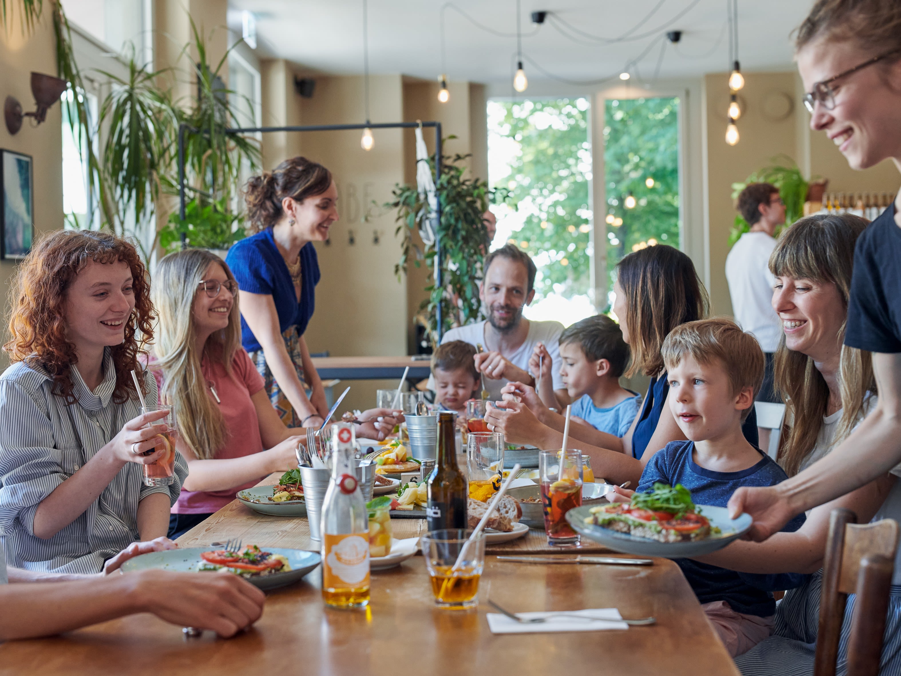 Une famille avec plusieurs enfants en train de bruncher autour d'une table bien garnie