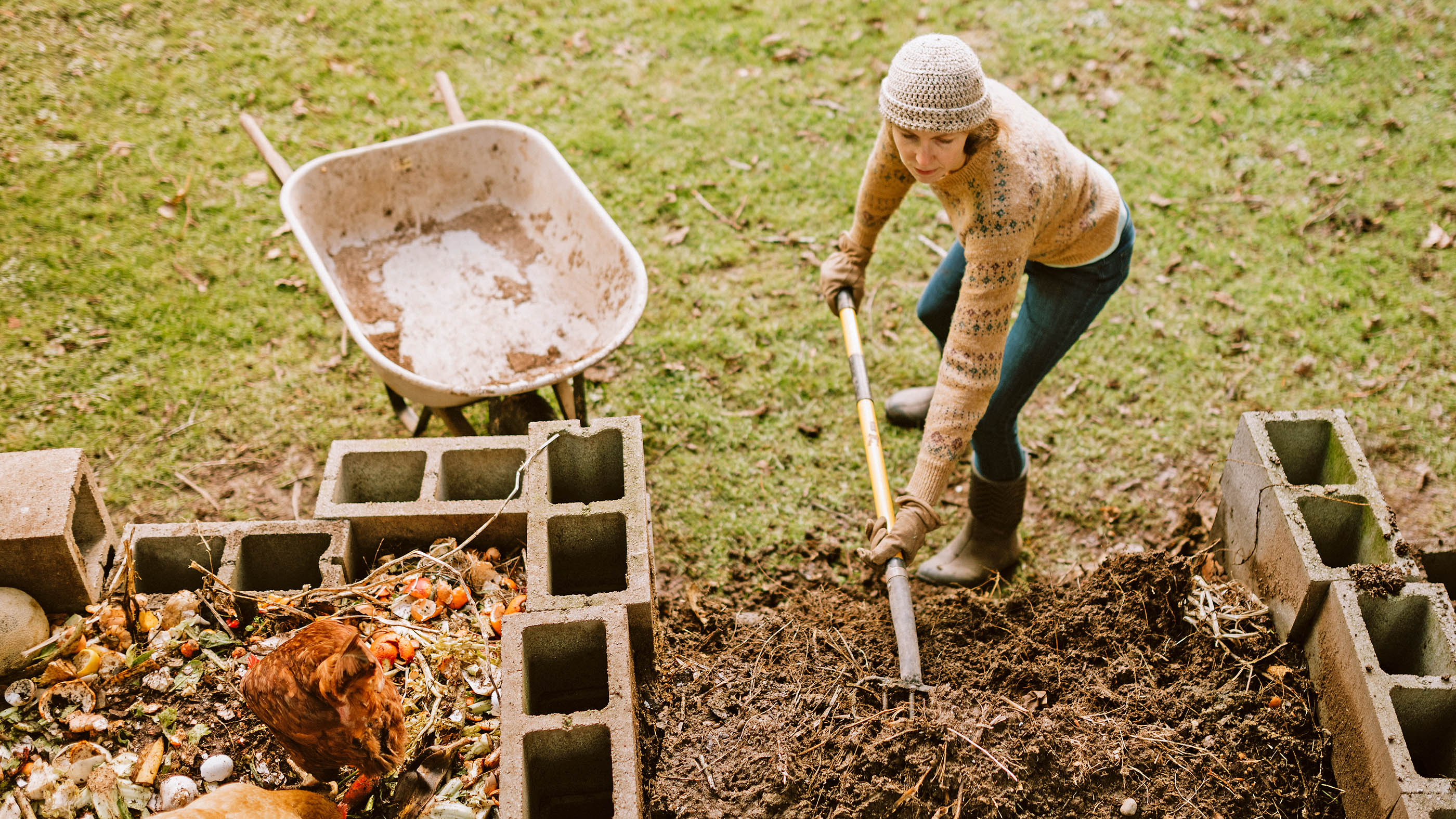 Une femme pellete du compost