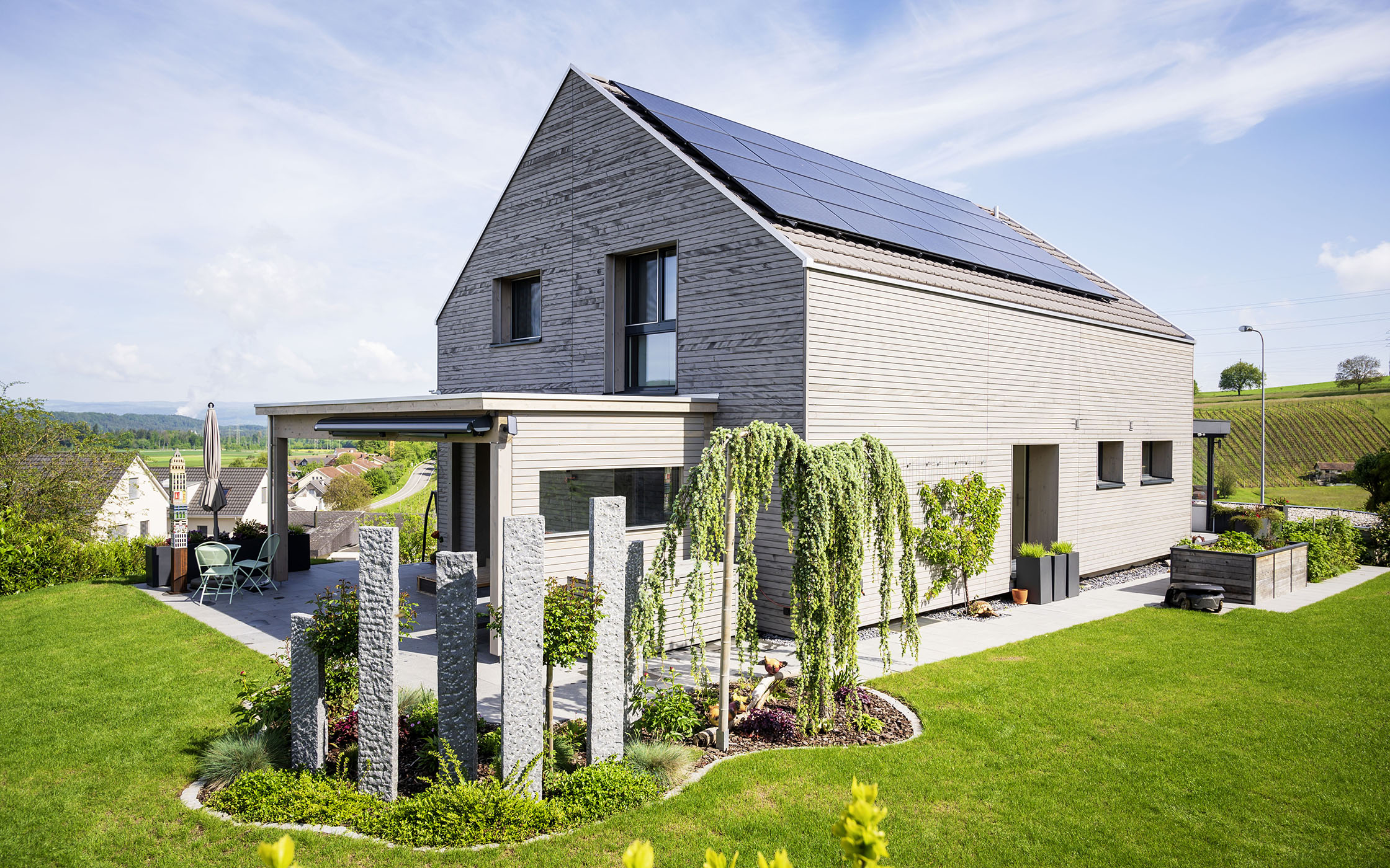 Una casa indipendente moderna con giardino e pannelli solari sul tetto