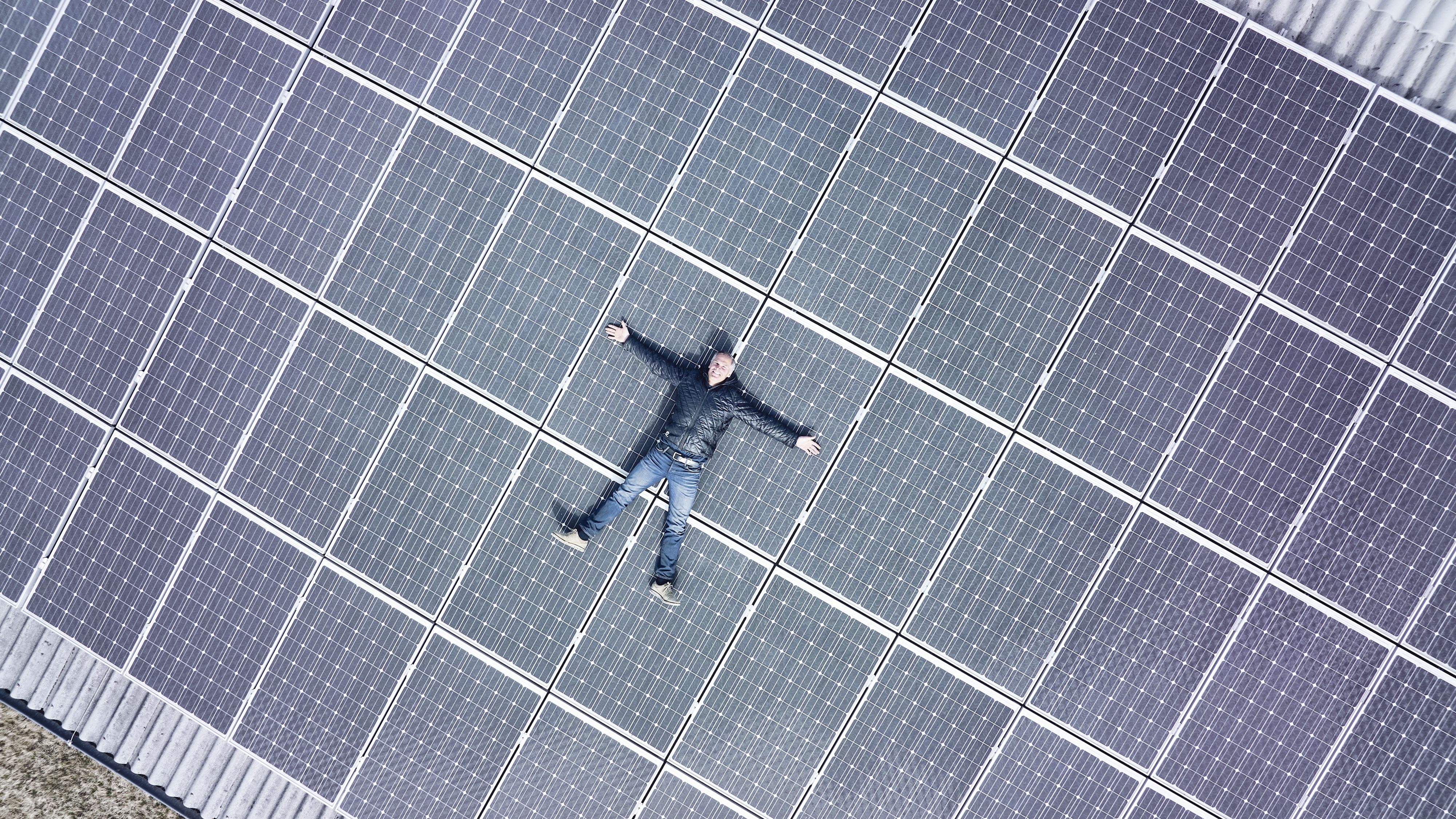 Renzo Blumenthal est allongé sur un grand système photovoltaïque sur son toit.