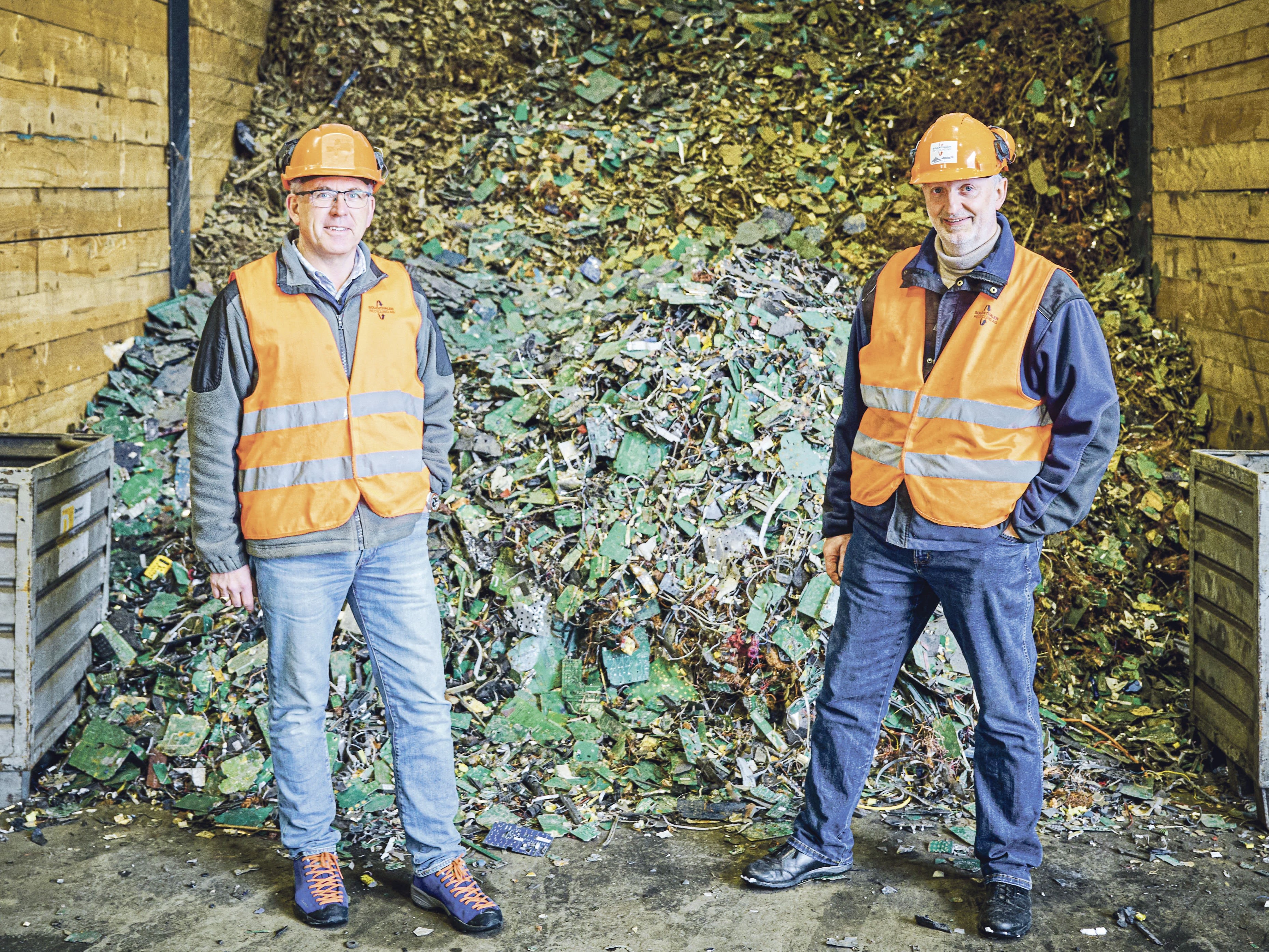 Deux hommes à Solenthaler Recycling AG à Gossau (SG) devant des appareils électriques démontés pour le recyclage