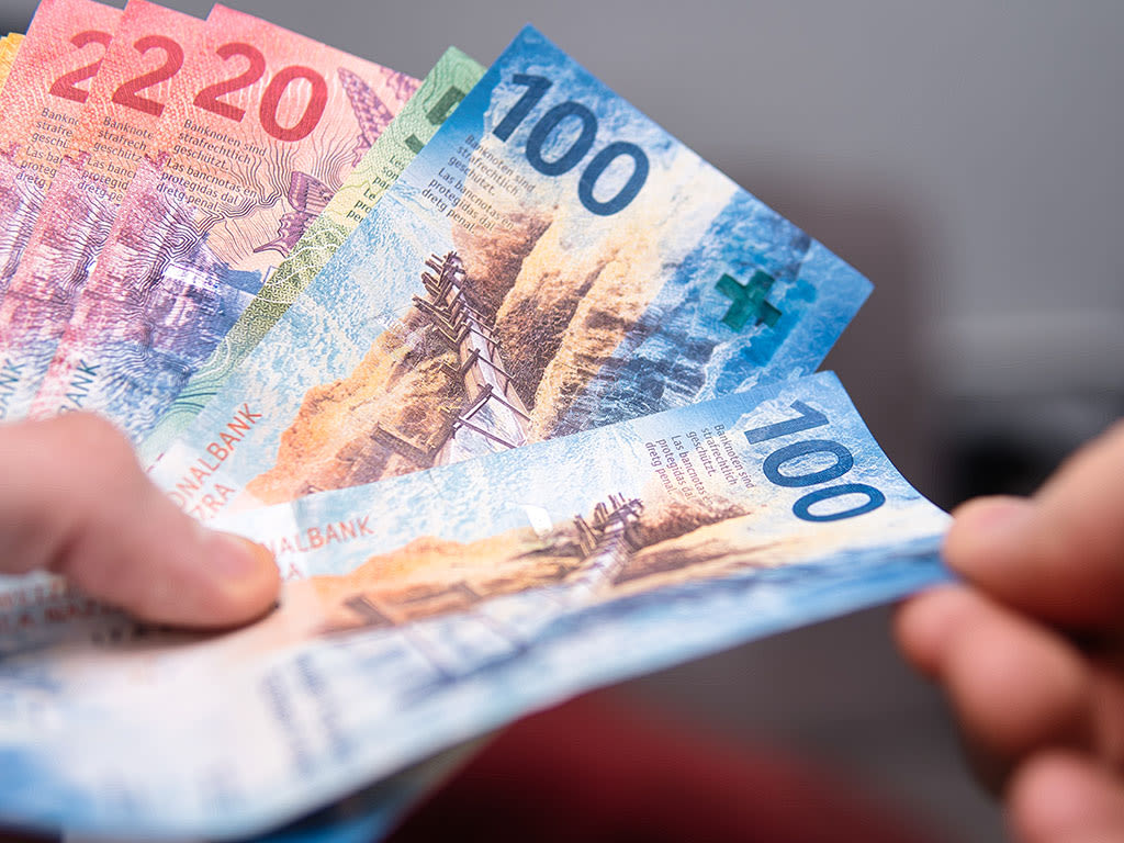 Hände halten Schweizer Banknoten