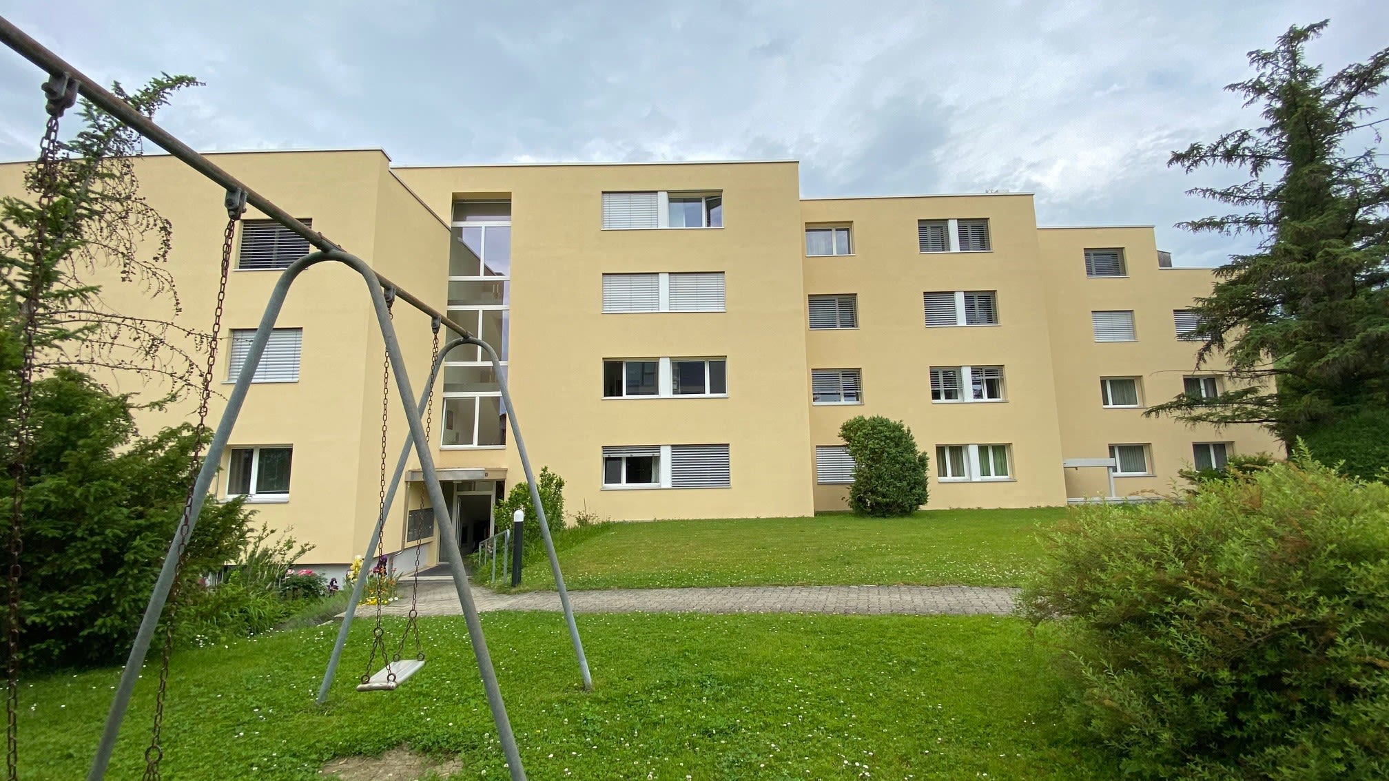 Un'altalena si trova nel giardino di un complesso residenziale.