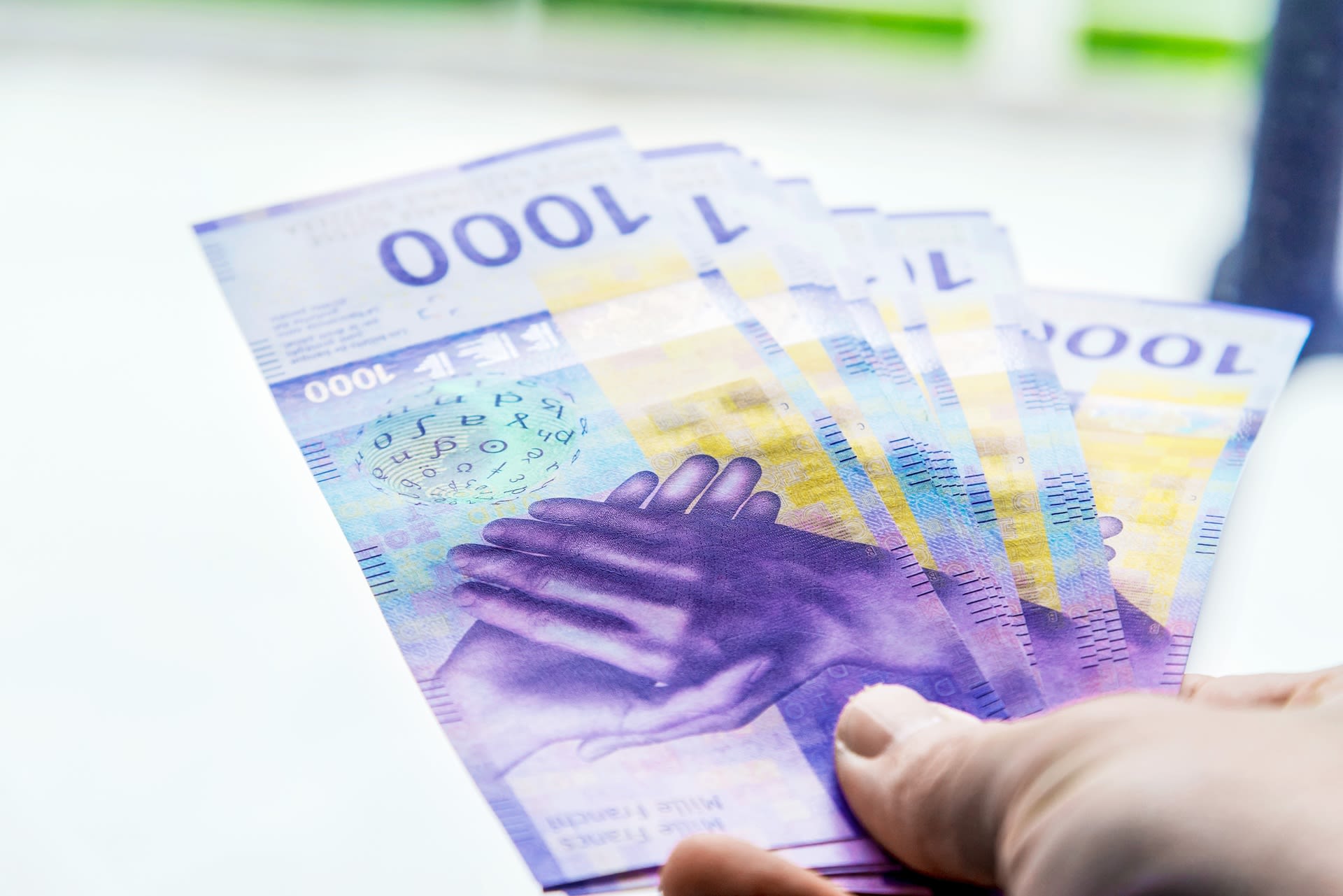 Una persona paga con diverse banconote da 1000 franchi