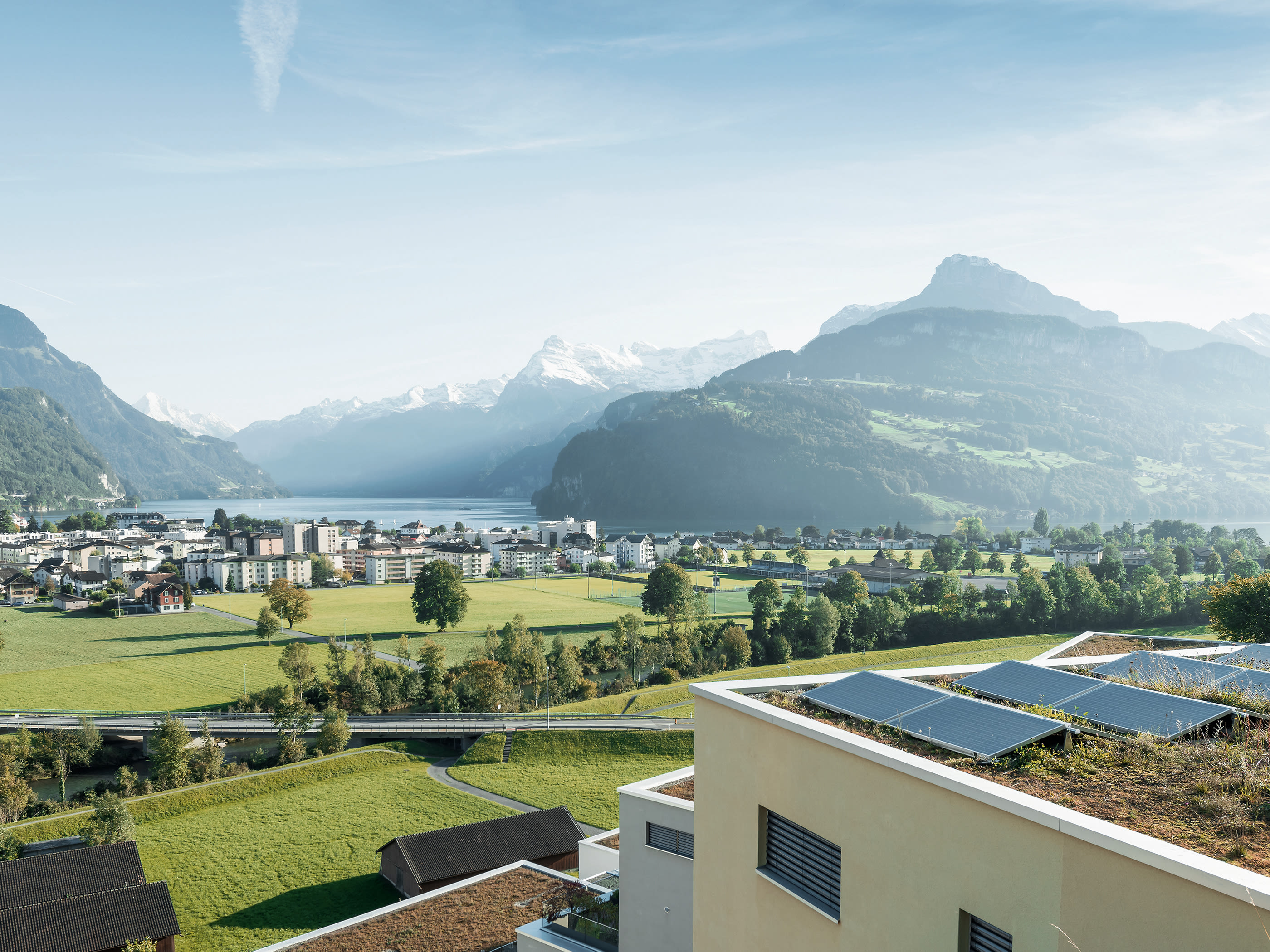Solarkollektoren auf Mehrfamilienhaus mit Blick auf die Alpen.