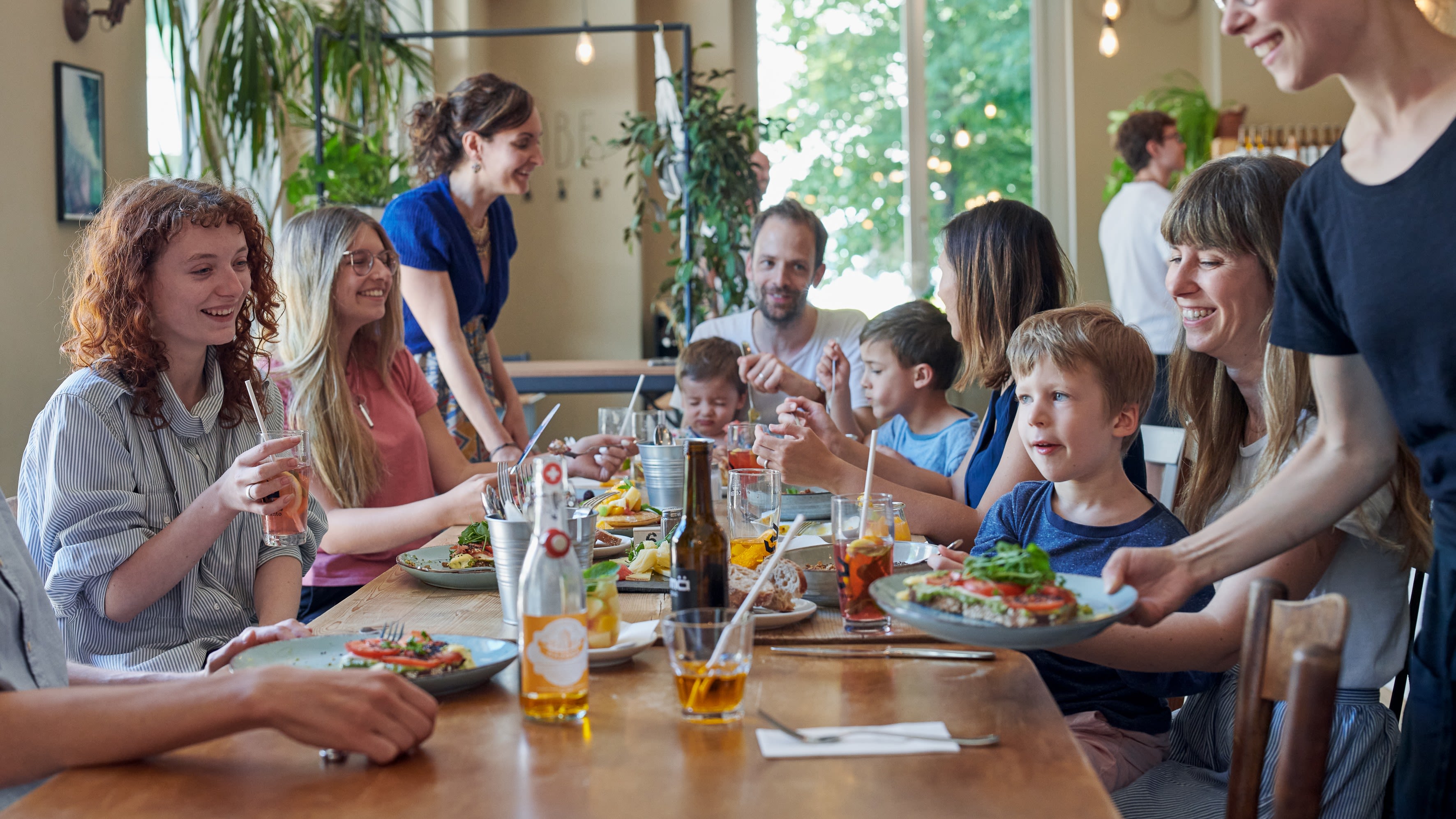 Une famille avec plusieurs enfants en train de bruncher autour d'une table bien garnie