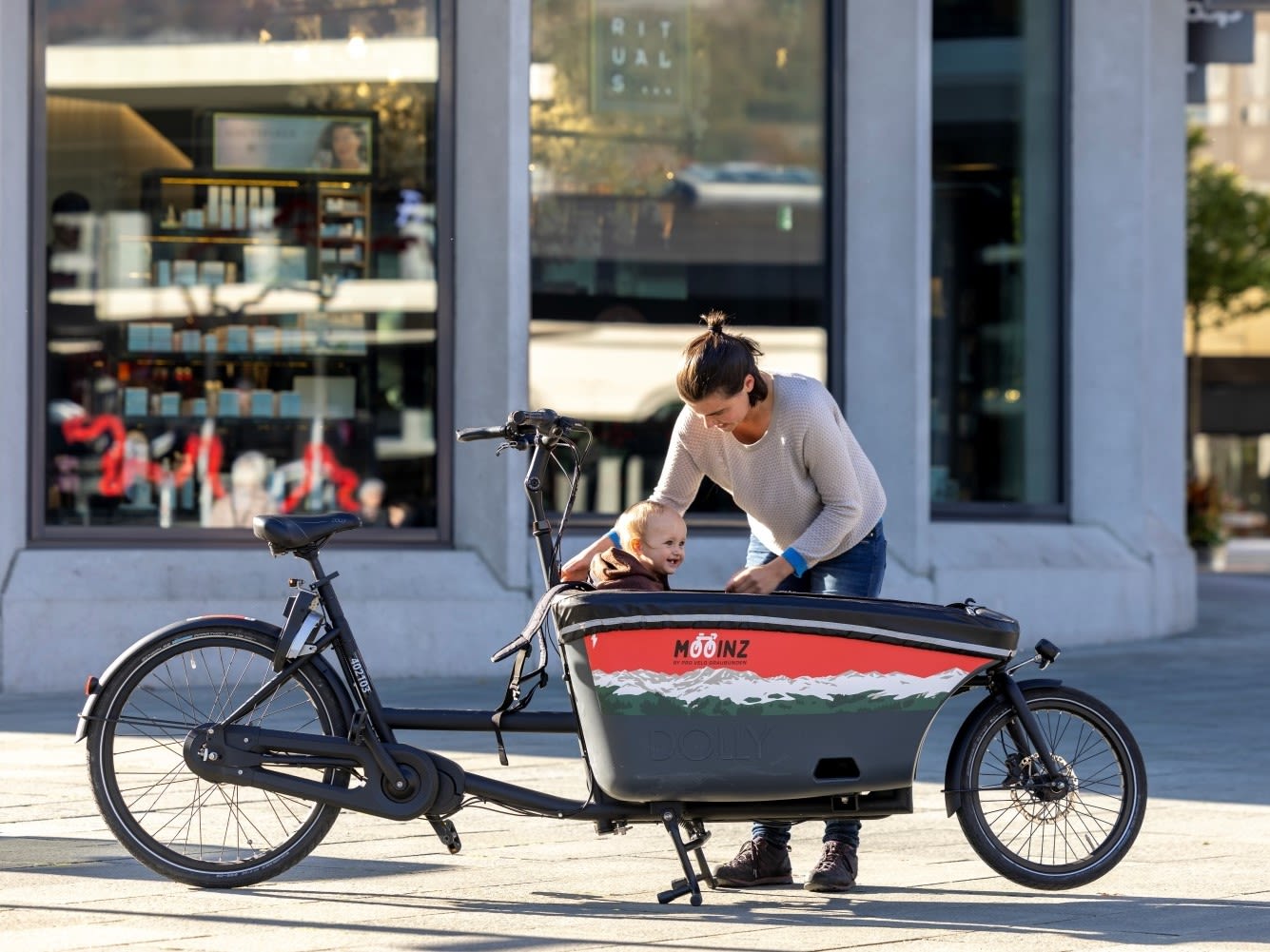 Eine Frau setzt ihr Kind in ein Carogvelo
