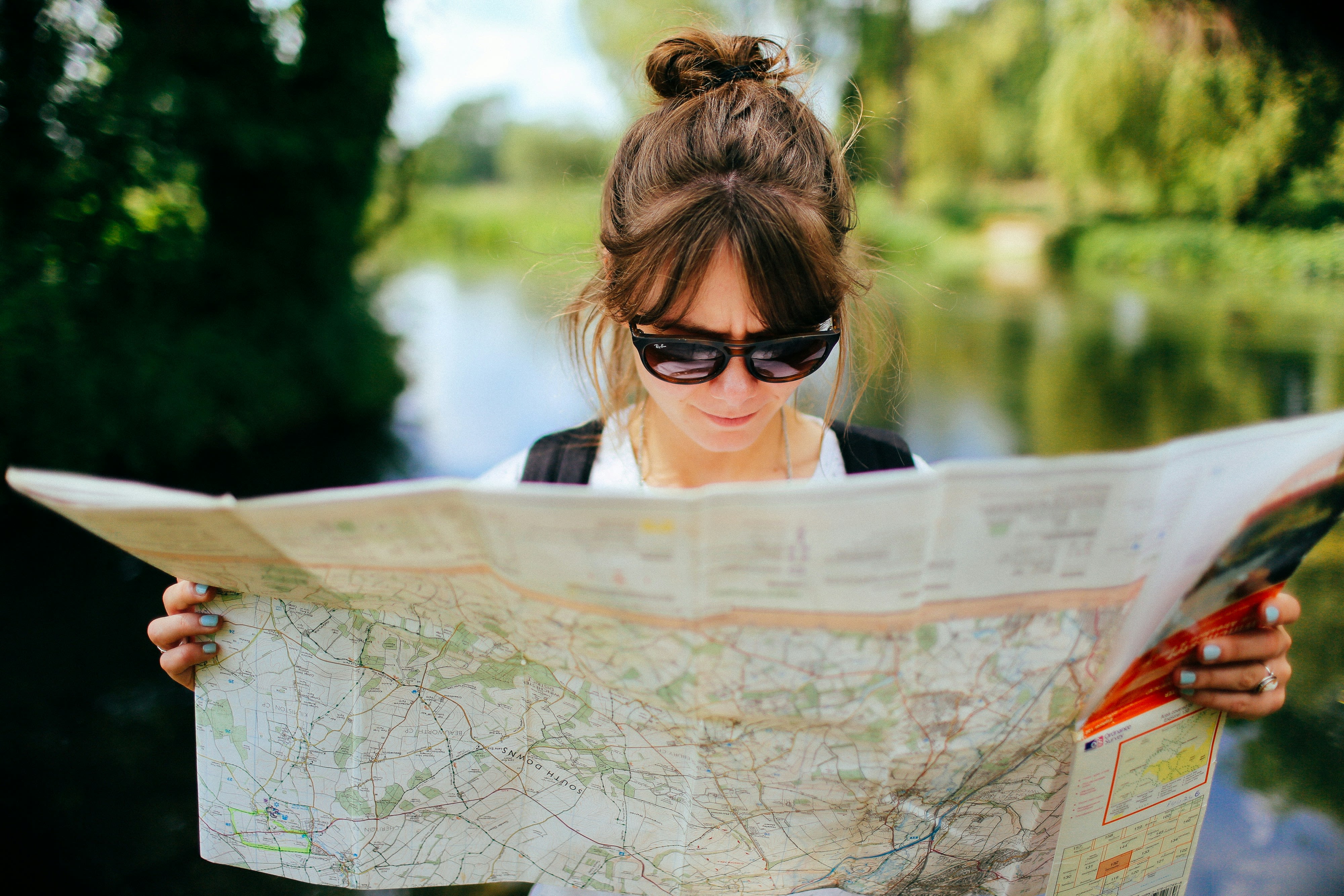 Femme avec des lunettes de soleil noires regardant une carte