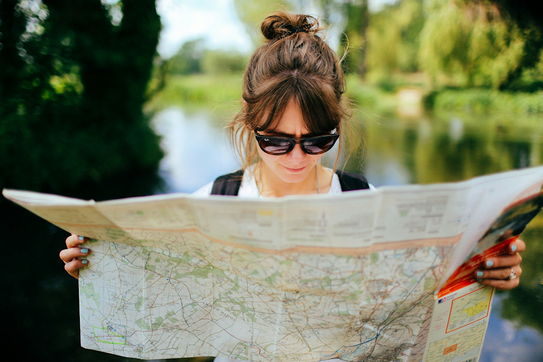 Femme avec des lunettes de soleil noires regardant une carte