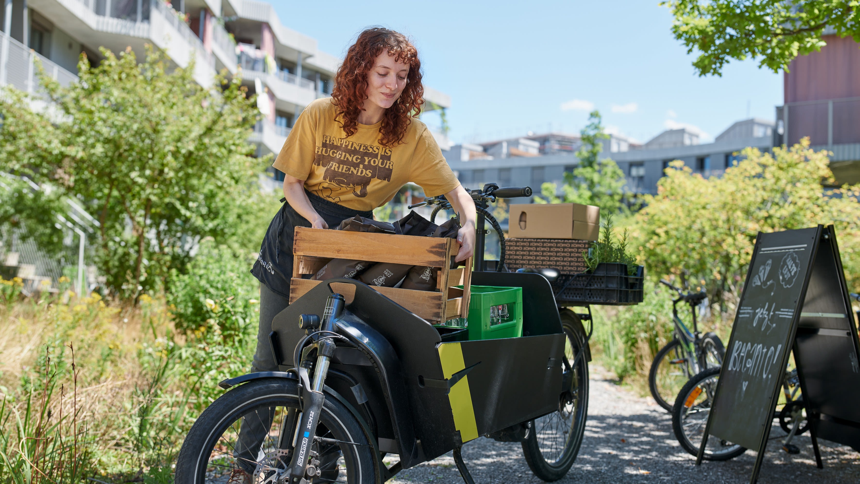 Une femme met une caisse sur un vélo cargo.