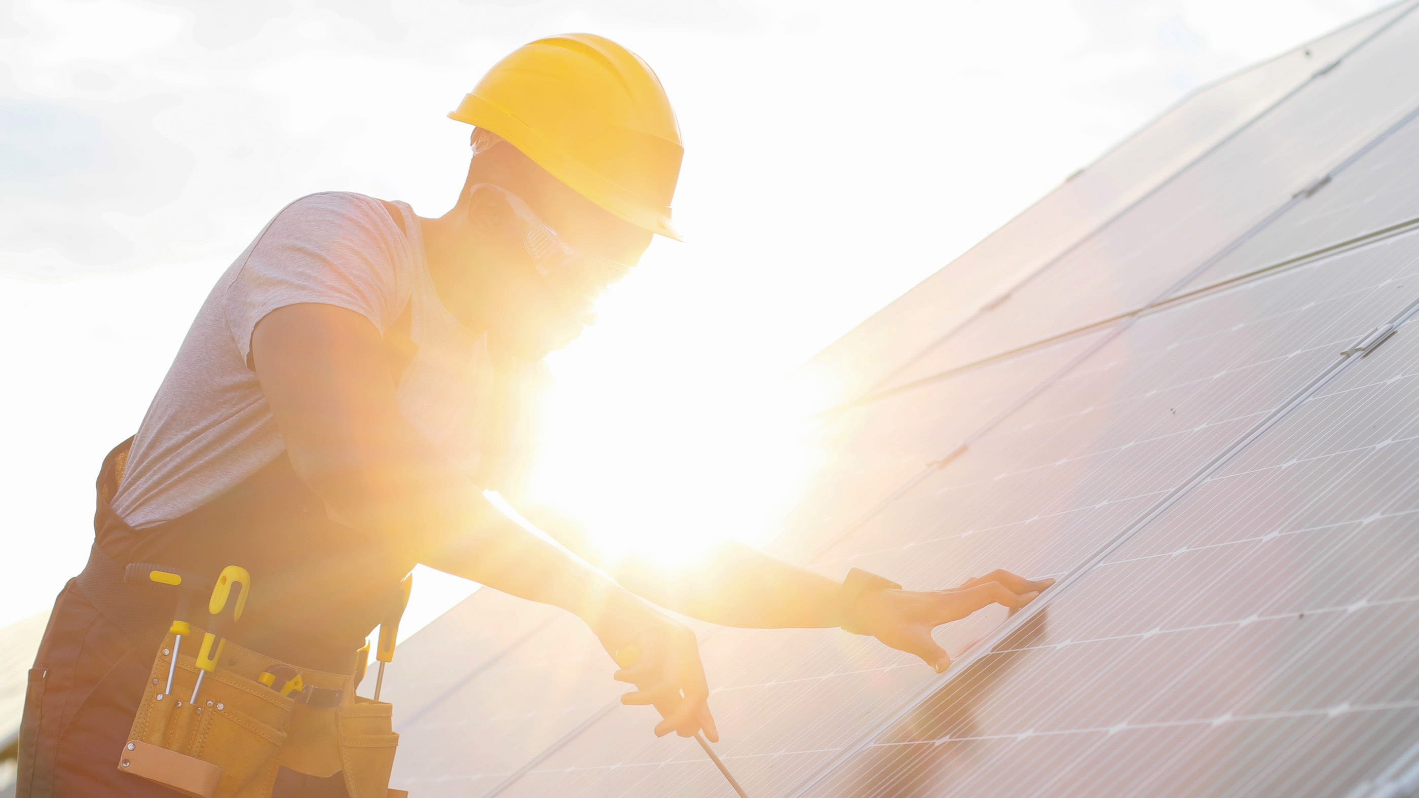 Une personne monte un système photovoltaïque sur le toit.