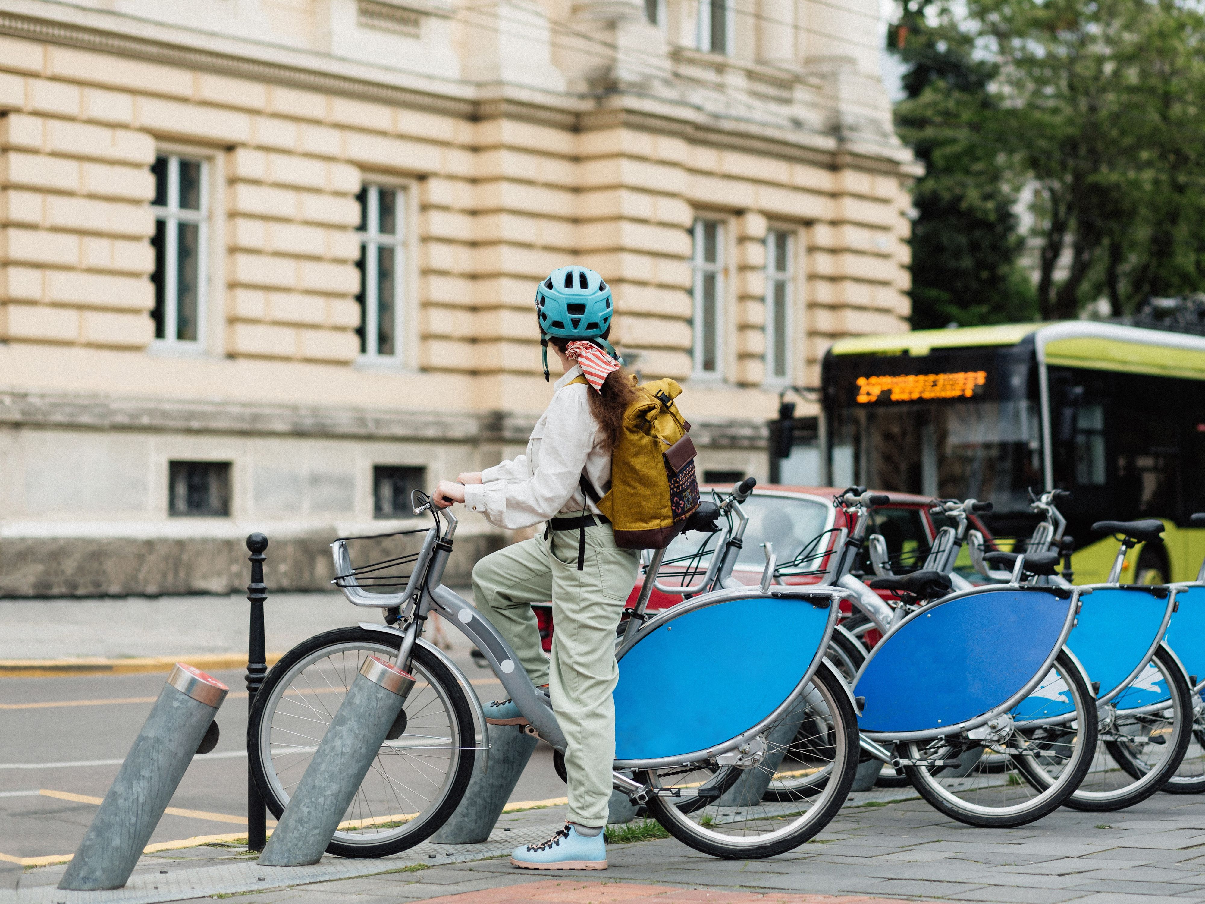 Frau auf einem Bikesharing Velo wartet, dass der Bus vorbeifährt.