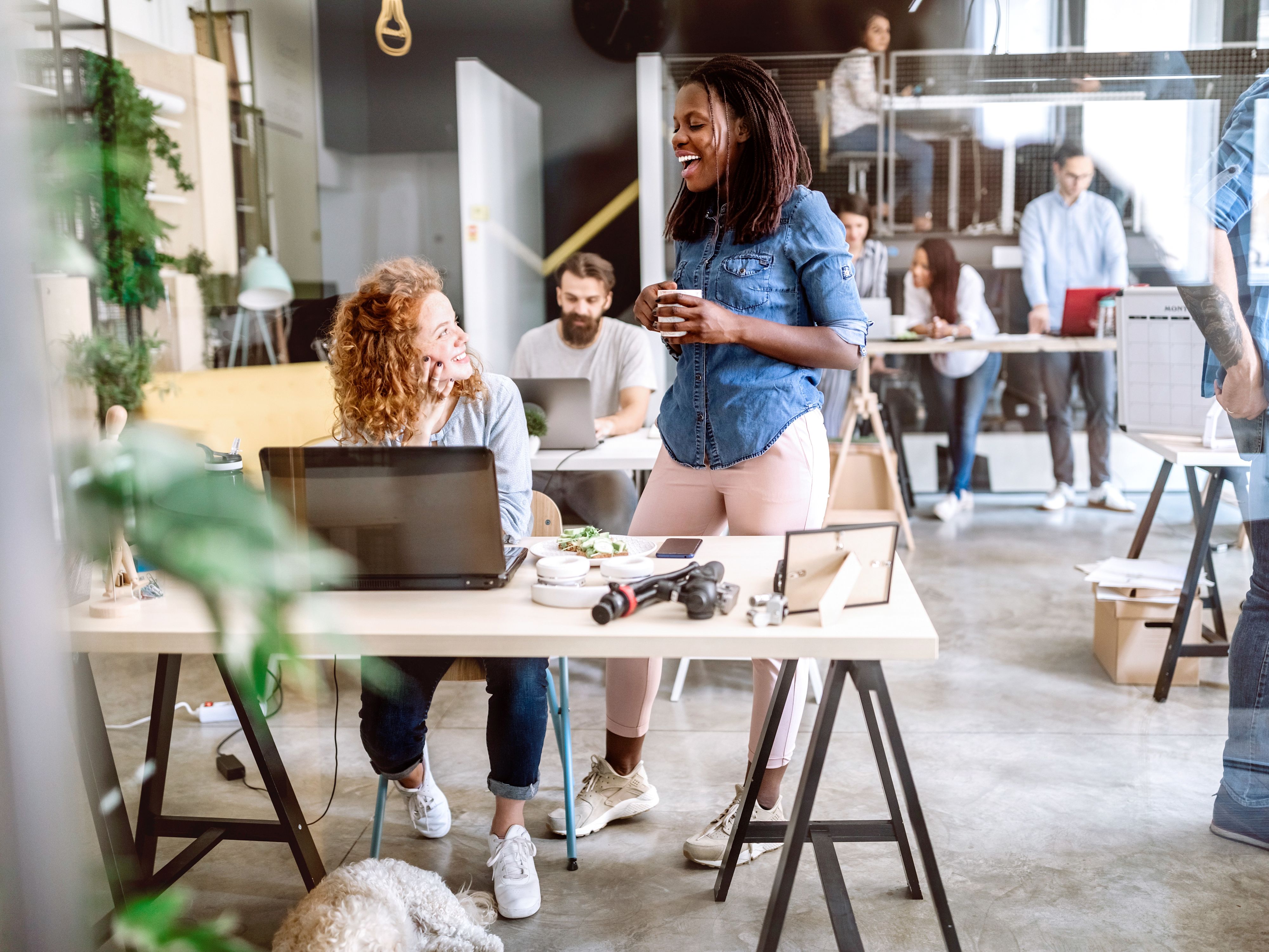 Deux femmes discutent dans un bureau.