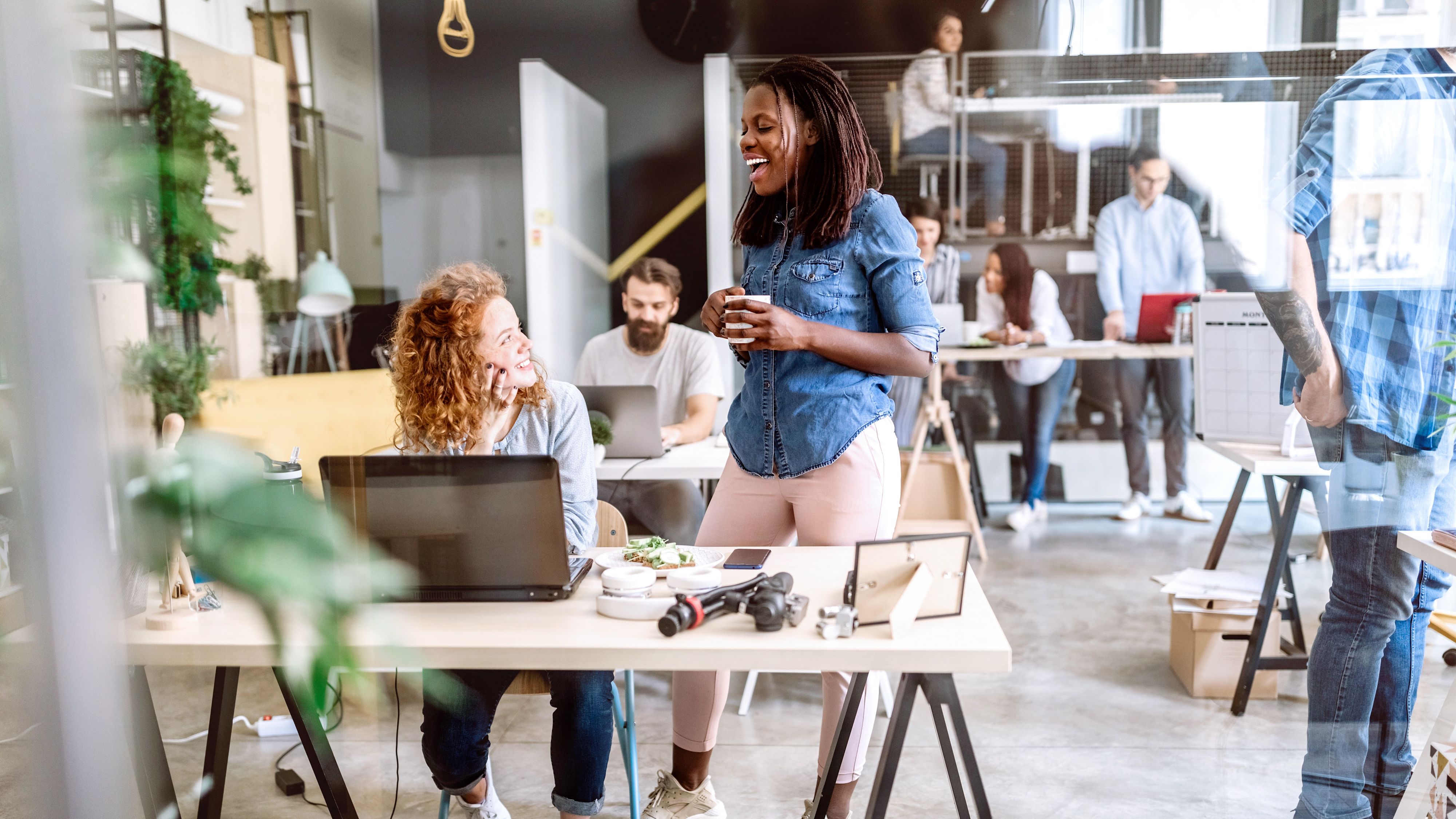 Deux femmes discutent dans un bureau.