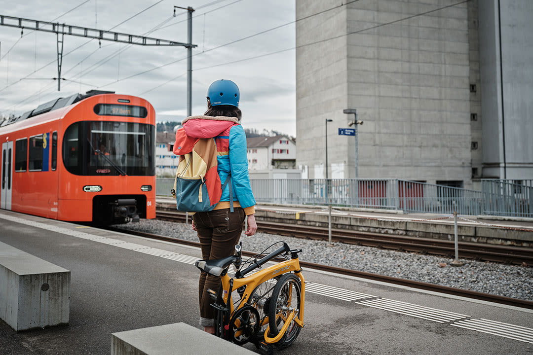 Eine Personen wartet mit ihrem Fahrrad am Bahnhof auf den Zug