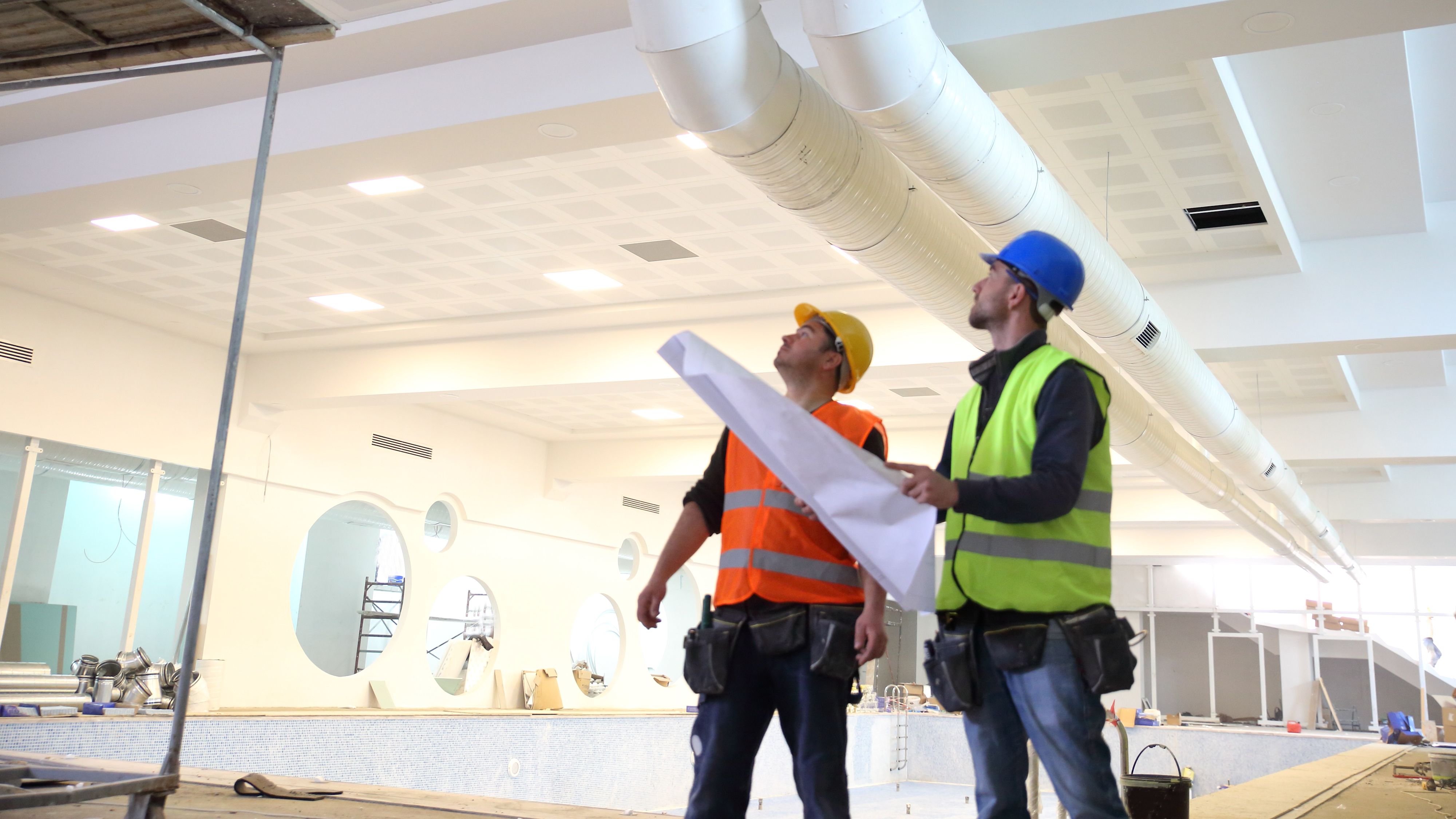 Arbeiter bei der Arbeit mit einem Lageplan in der Hand
