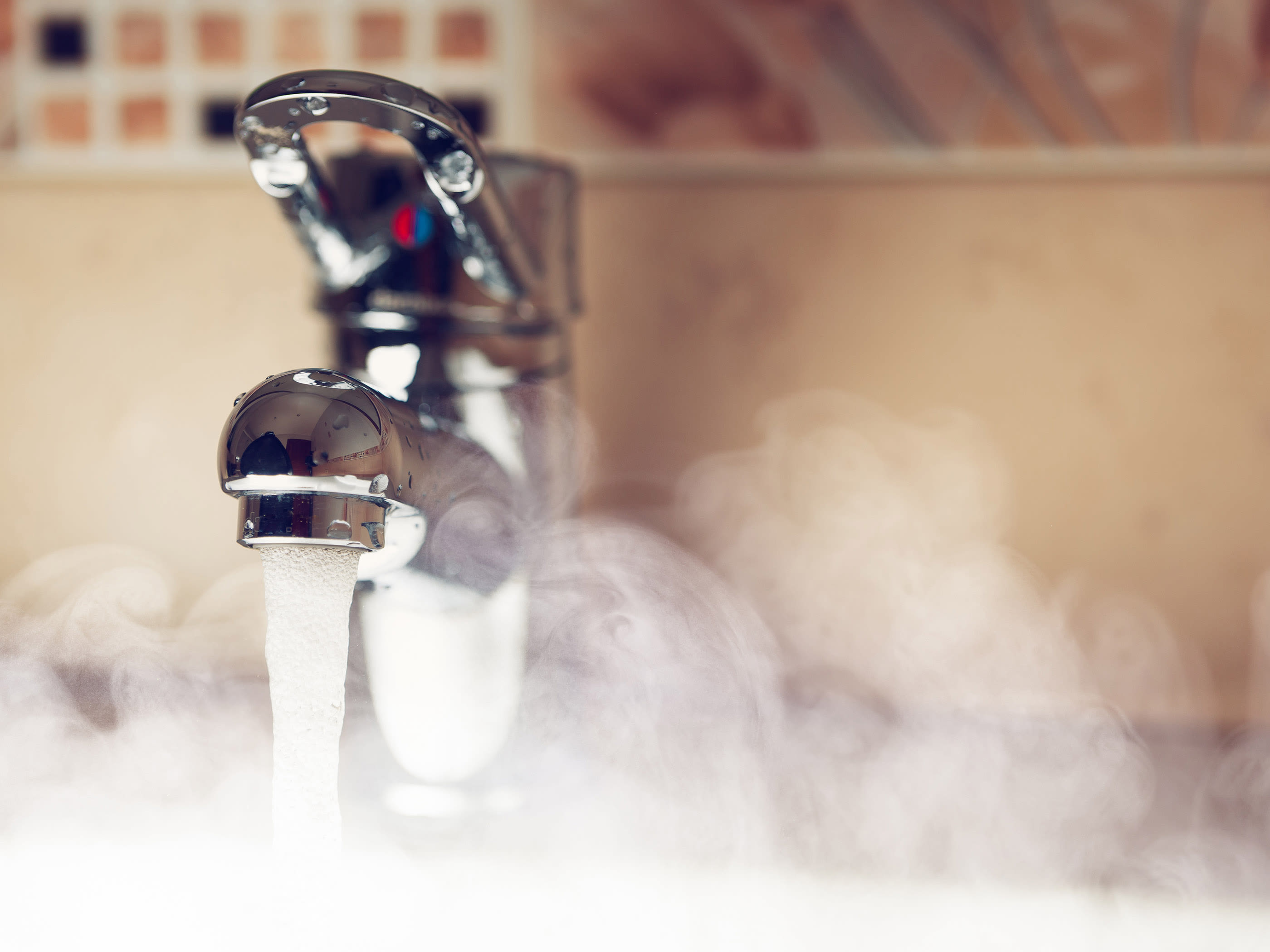 L'acqua calda scorre da un rubinetto.
