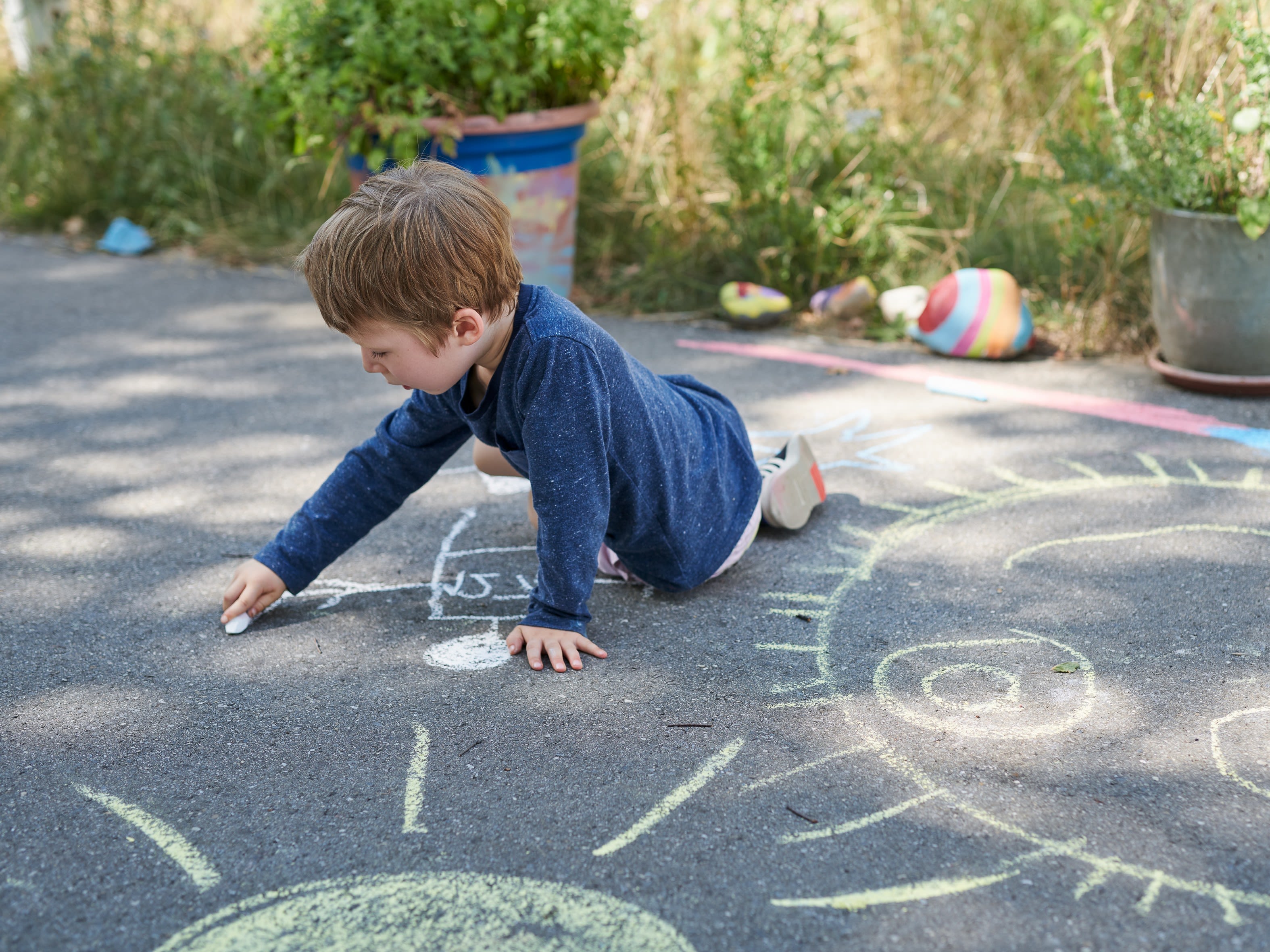 Enfant dessinant à la craie au sol