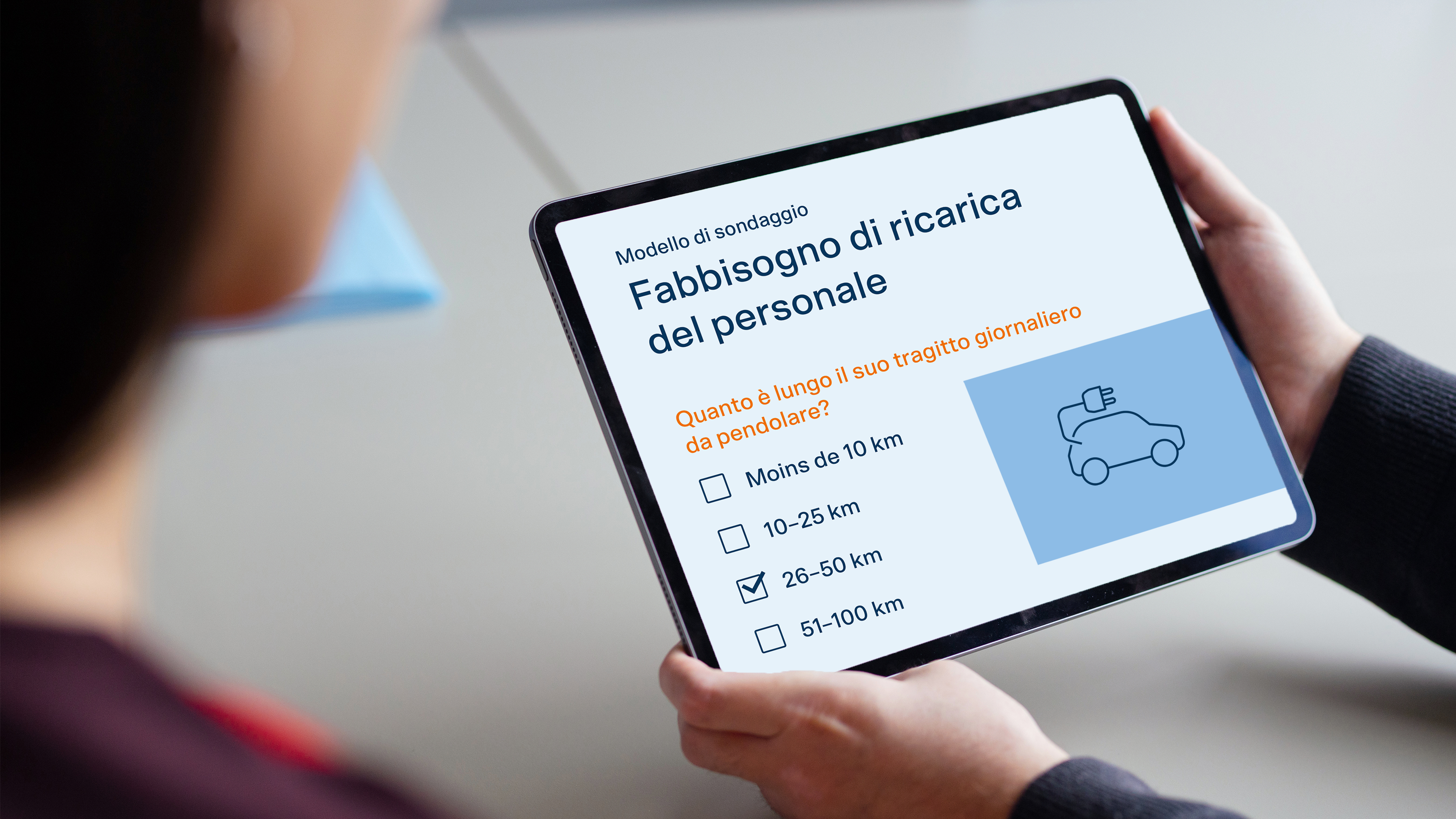 Una persona tiene in mano un tablet su cui è visualizzato il sondaggio.