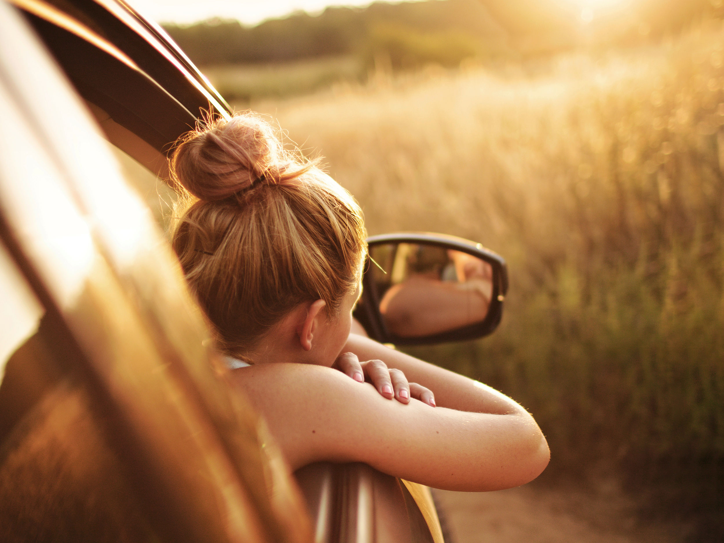 Une femme regarde au loin par la fenêtre de la voiture.